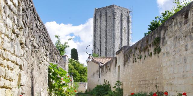 Tour Carrée de Loudun derrière une rue de coquelicots