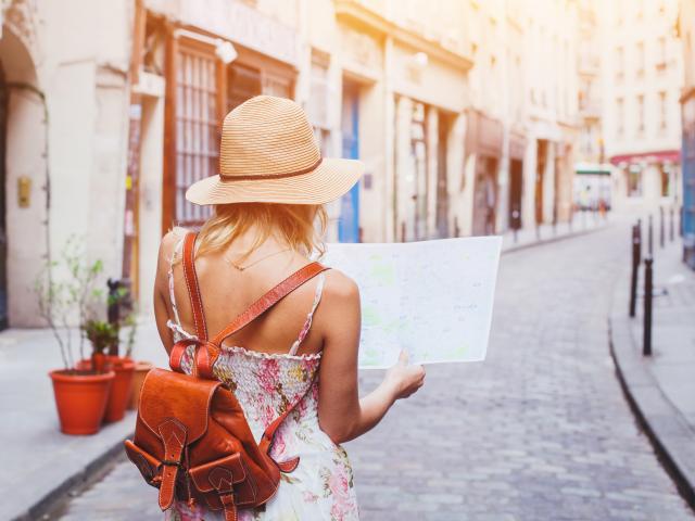 woman tourist looking at the map on the street of european city, travel to Europe