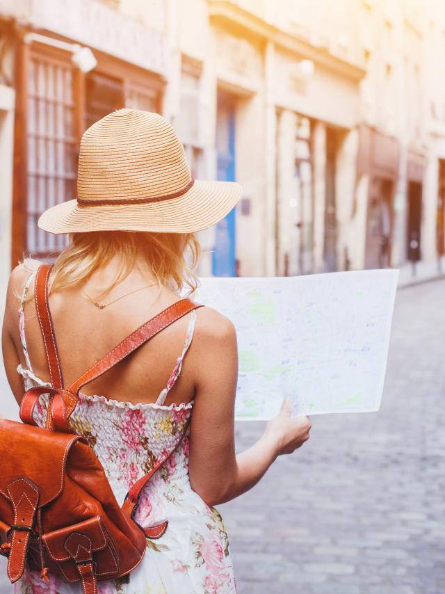 woman tourist looking at the map on the street of european city, travel to Europe